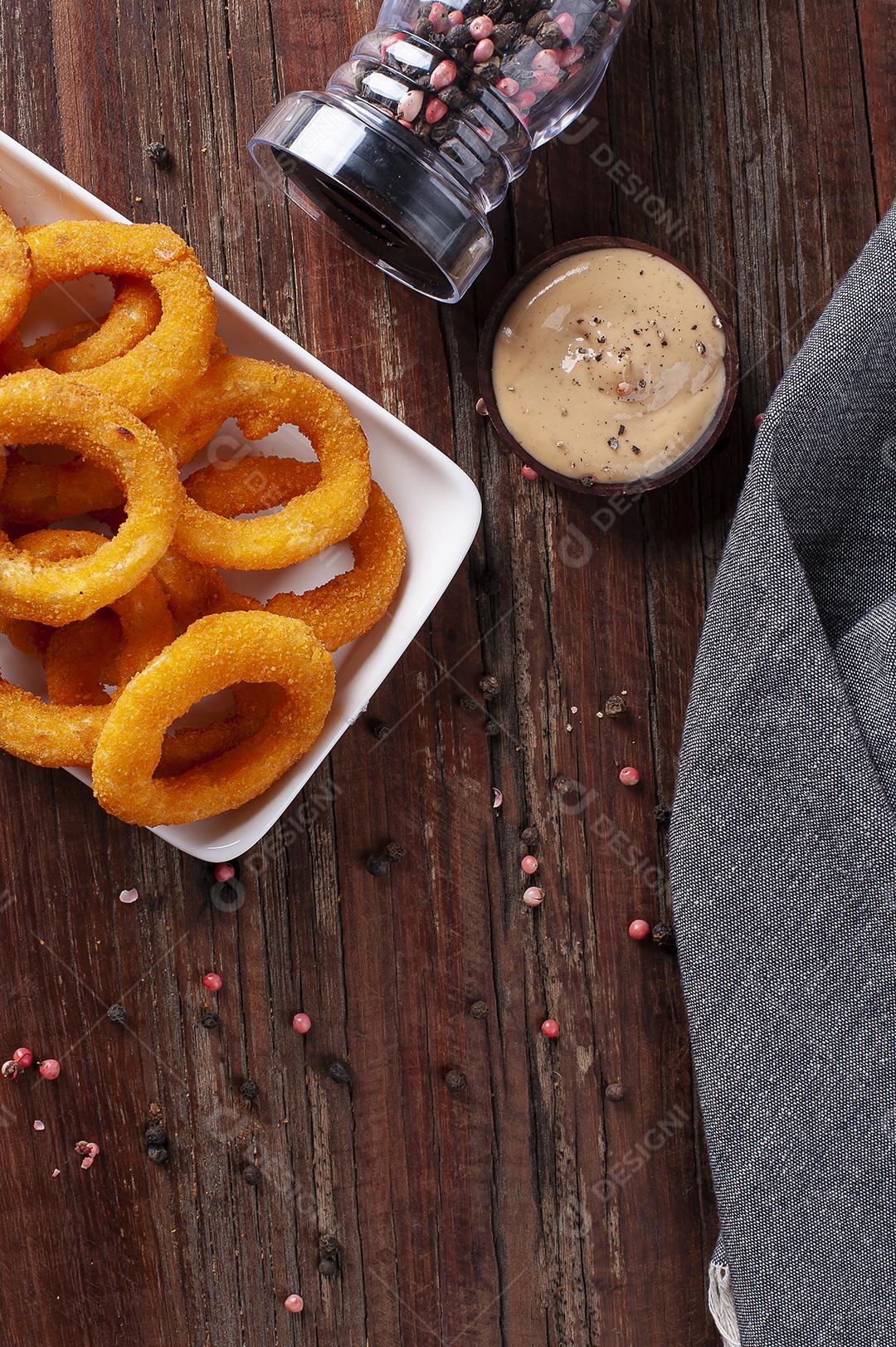 Deliciosos anéis de cebola fritos crocantes caseiros com molho picante