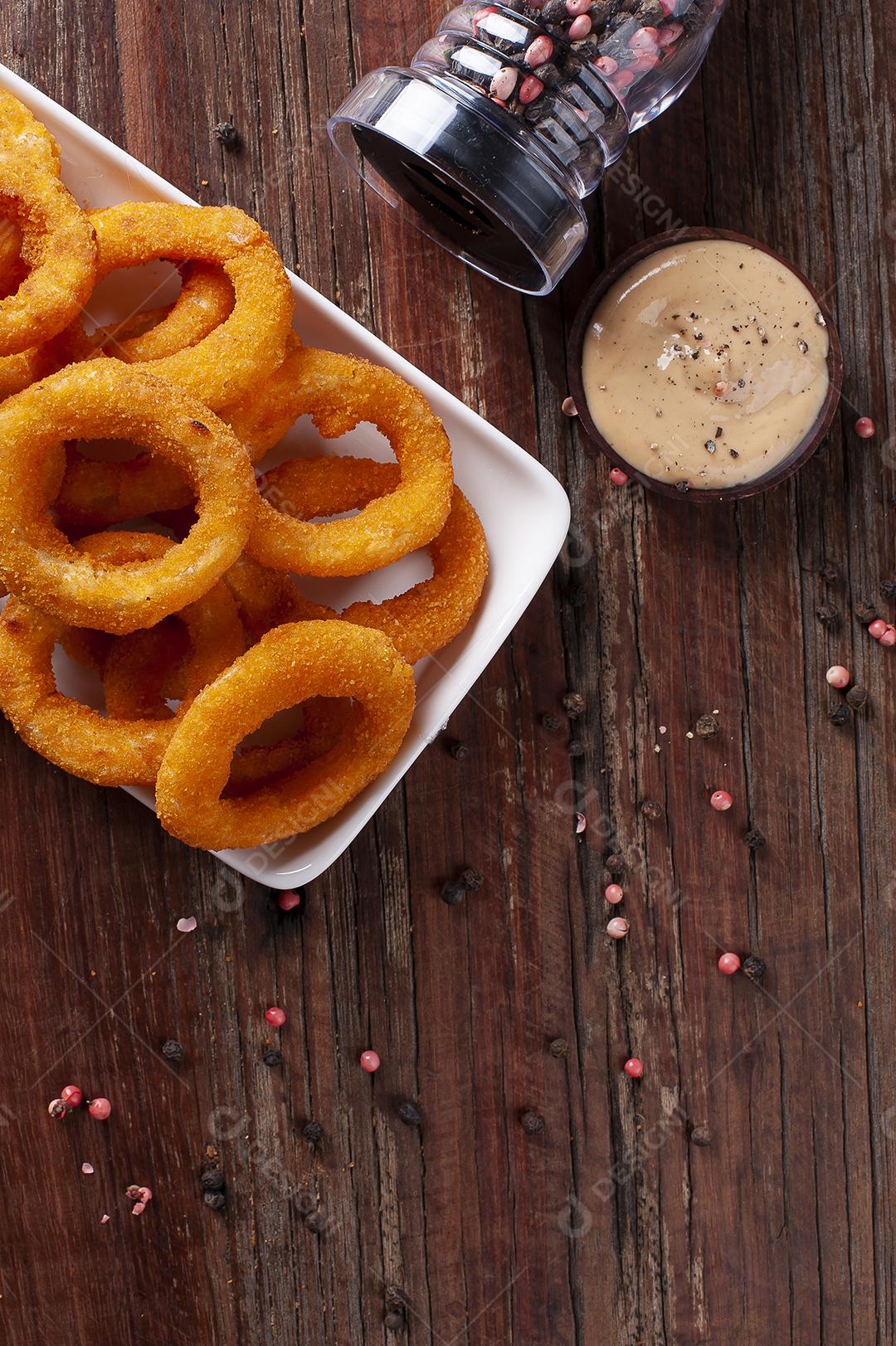 Deliciosos anéis de cebola fritos crocantes caseiros com molho picante
