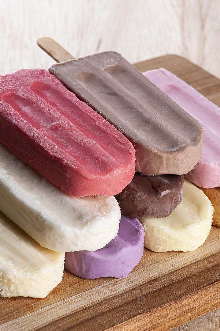 Vários picolés são colocados no fundo da tábua de madeira JPG