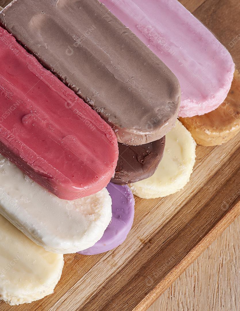 Vários picolés são colocados no fundo da tábua de madeira JPG