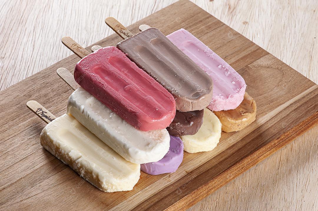 Vários picolés são colocados no fundo da tábua de madeira JPG