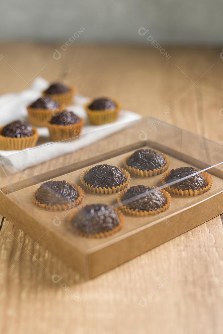 caixa transparente cheia de Brigadeiro Doce Brasileiro. em uma madeira
