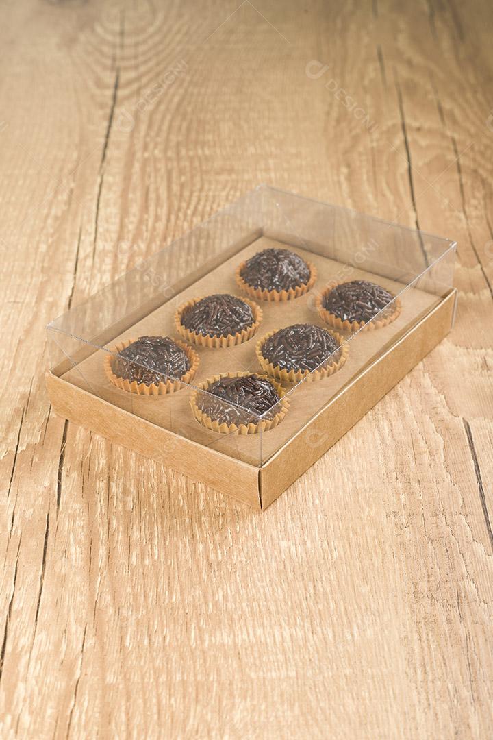 caixa transparente cheia de Brigadeiro Doce Brasileiro. em uma madeira