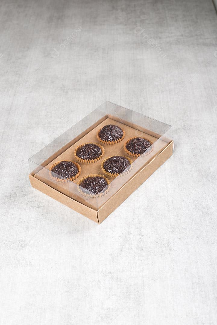 caixa transparente cheia de Brigadeiro Doce Brasileiro. em uma madeira