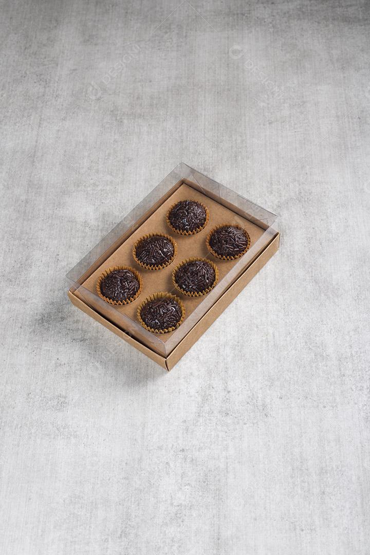 caixa transparente cheia de Brigadeiro Doce Brasileiro. em uma madeira