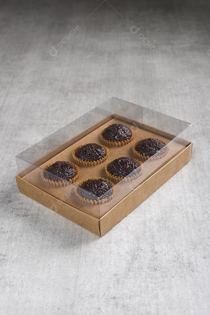 caixa transparente cheia de Brigadeiro Doce Brasileiro. em uma madeira