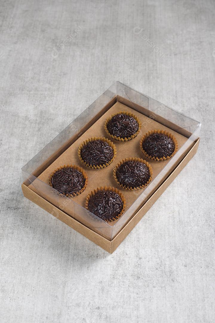 caixa transparente cheia de Brigadeiro Doce Brasileiro. em uma madeira