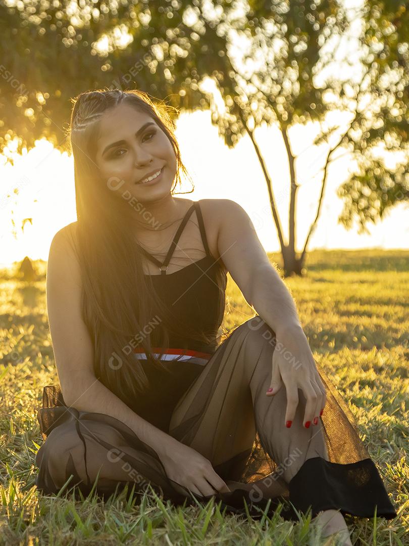 Linda menina morena posando em fotos na natureza por do sol