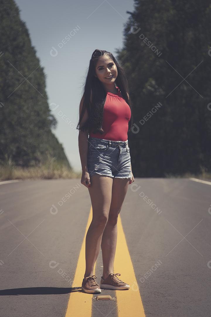 Linda menina morena posando em fotos na natureza por do sol