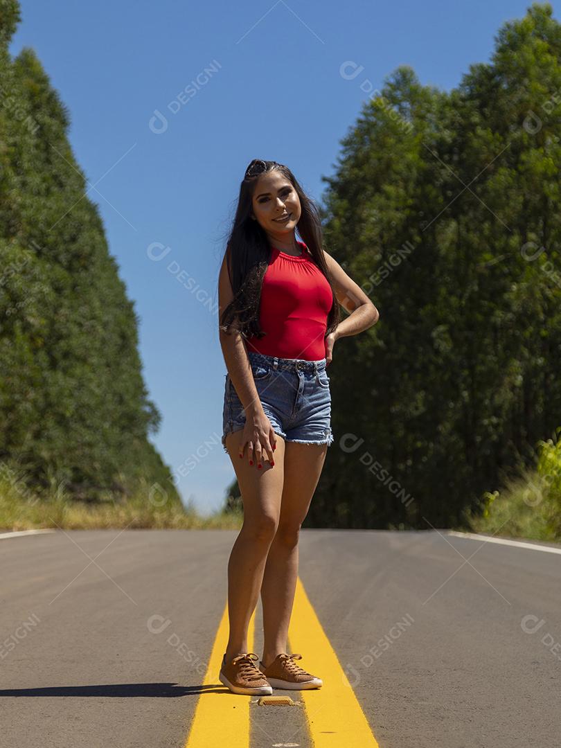 Linda menina morena posando em fotos na natureza por do sol