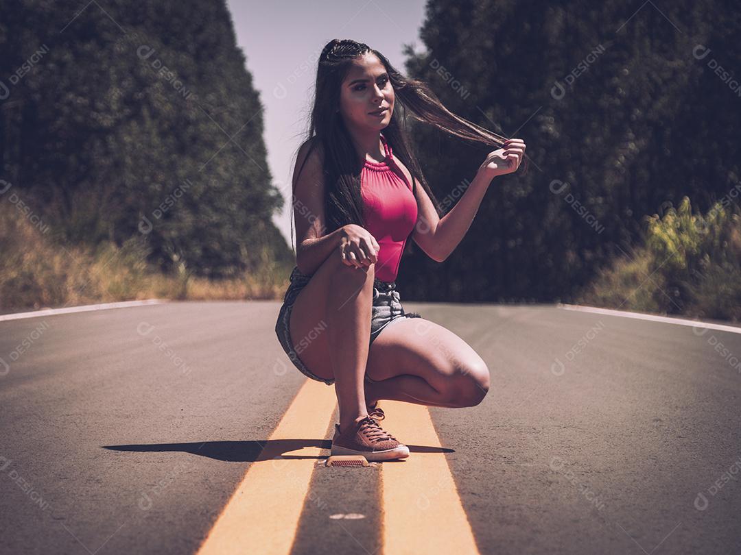 Linda menina morena posando em fotos na natureza por do sol