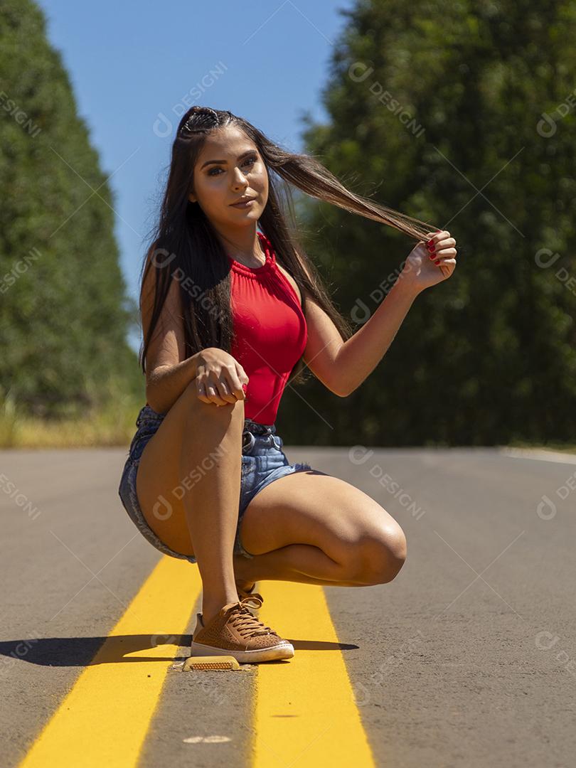 Linda menina morena posando em fotos na natureza por do sol