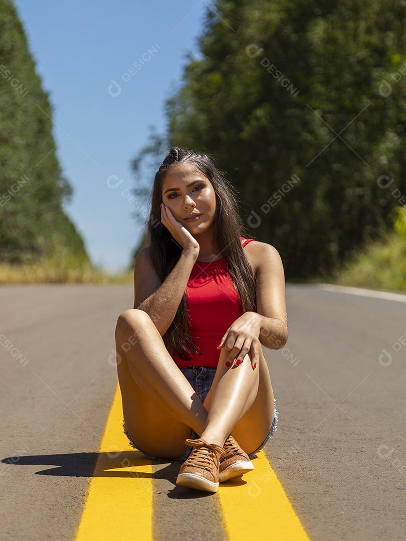 Linda menina morena posando em fotos na natureza por do sol