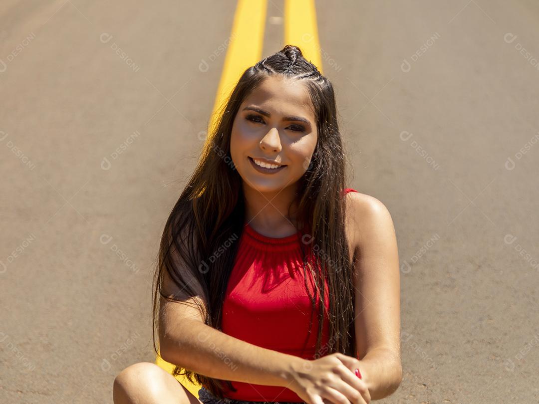 Linda menina morena posando em fotos na natureza por do sol