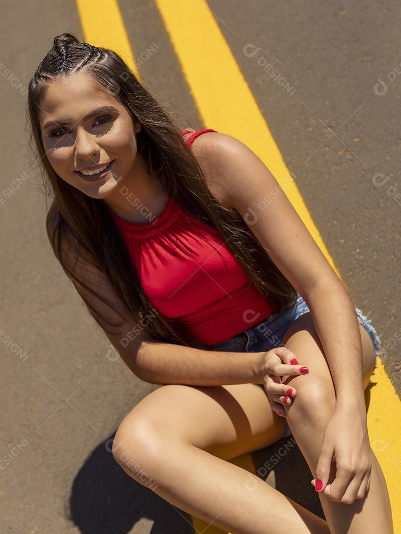 Linda menina morena posando em fotos na natureza por do sol