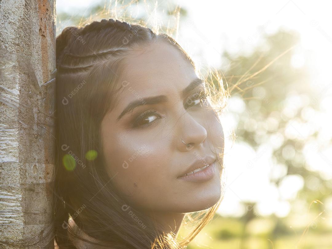 Linda menina morena posando em fotos na natureza por do sol