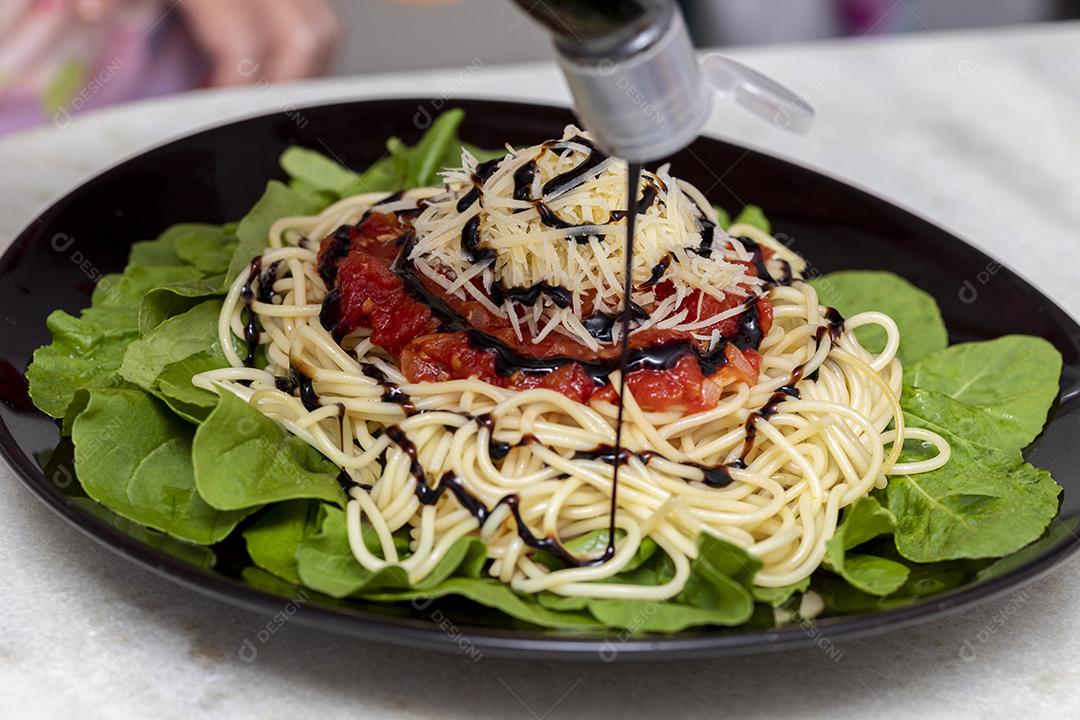 Macarrão espaguete com molho vermelho e rúcula Imagem JPG
