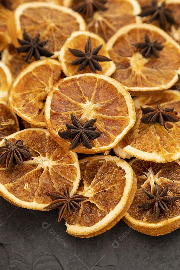 Fatias de laranja desidratada e anis estrelado em pedra preta
