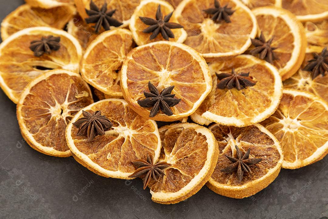 Fatias de laranja desidratada e anis estrelado em pedra preta