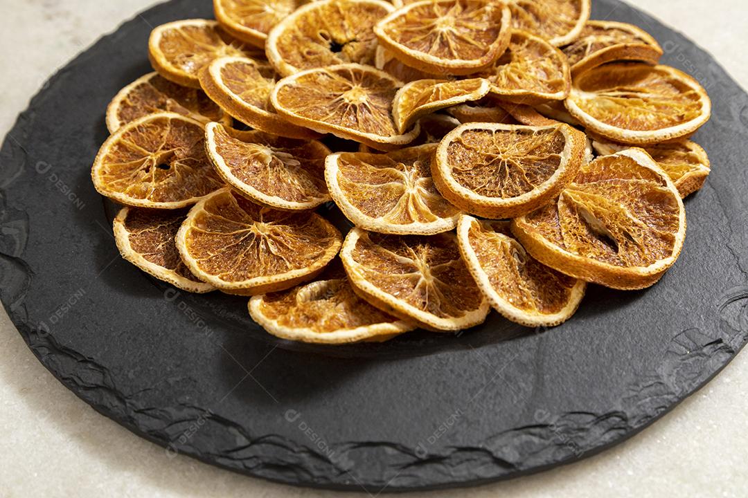 Fatias de laranja desidratada em pedra preta