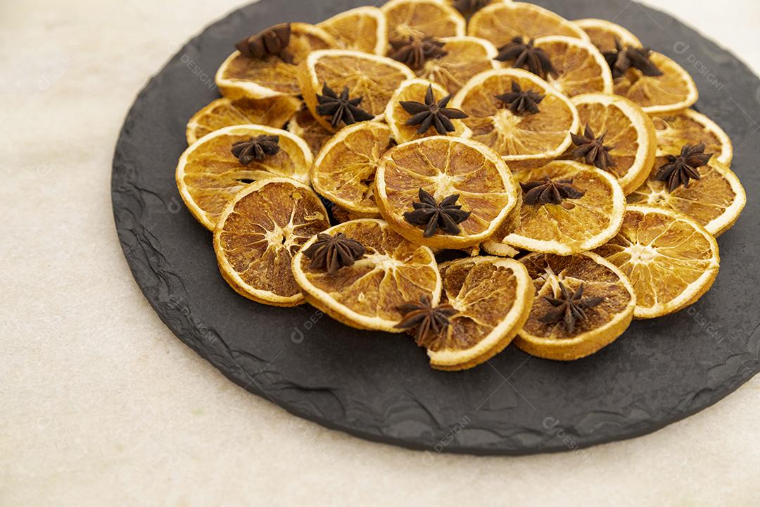 Fatias de laranja desidratada e anis estrelado em pedra preta
