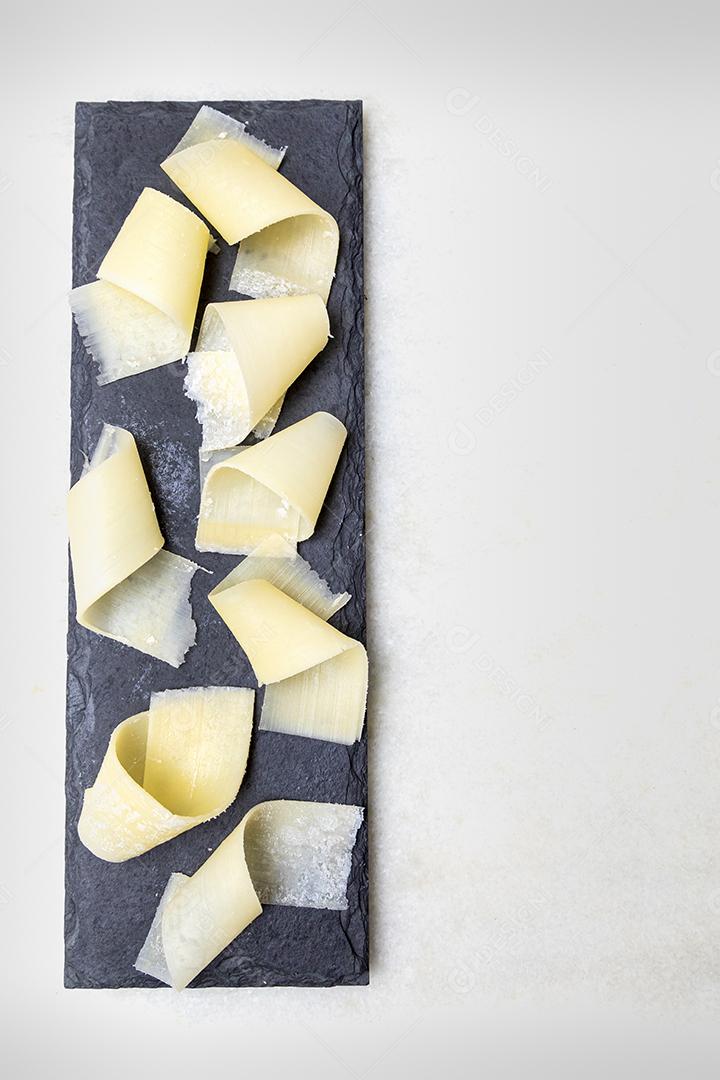 Porção de queijo parmesão em flocos com vinagre balsâmico em pedra preta