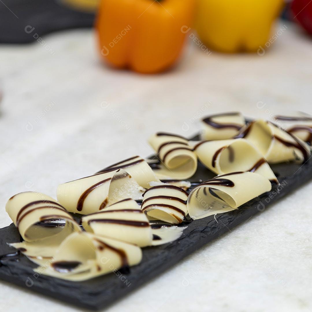 Porção de queijo parmesão em flocos com vinagre balsâmico em pedra preta