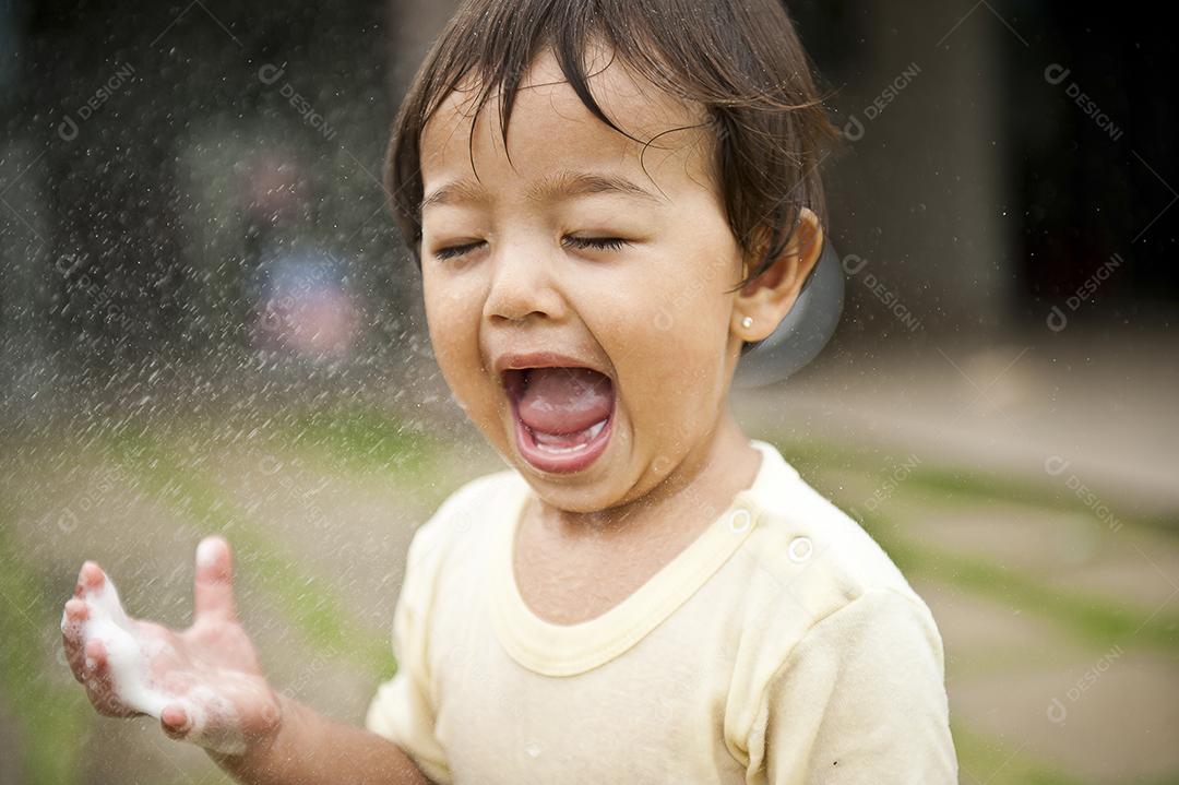 Garota sorrindo e se divertindo com a água espirrando JPG