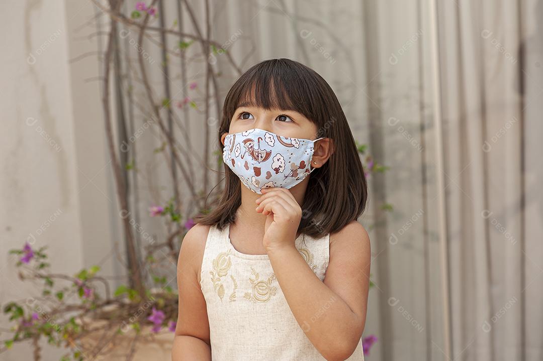 Garota asiática usando uma máscara para se proteger de Covid JPG