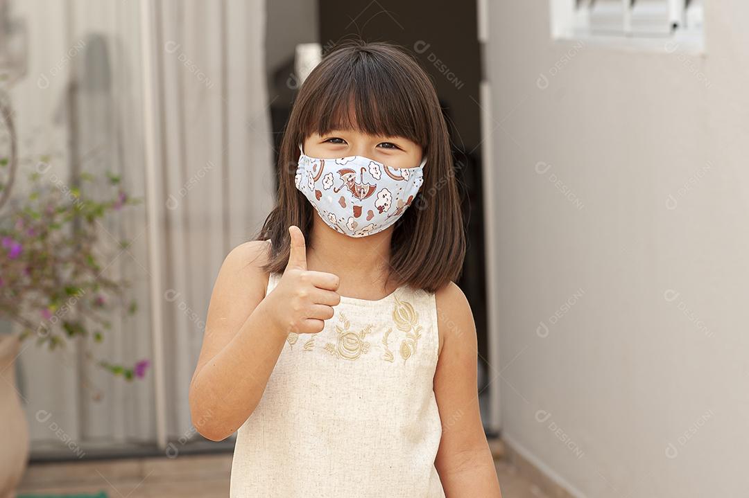 Asian-looking girl wearing a mask to protect herself from Covid-19 or corona virus JPG