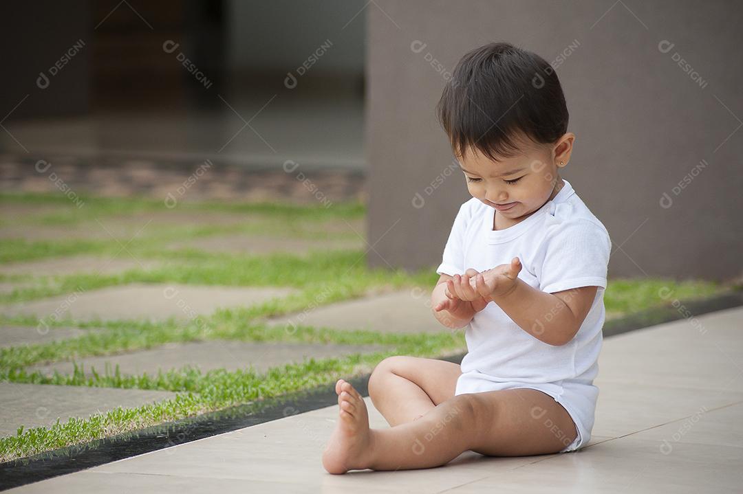 Retrato de menina de 1 ano de aparência asiática brincando sozinha JPG