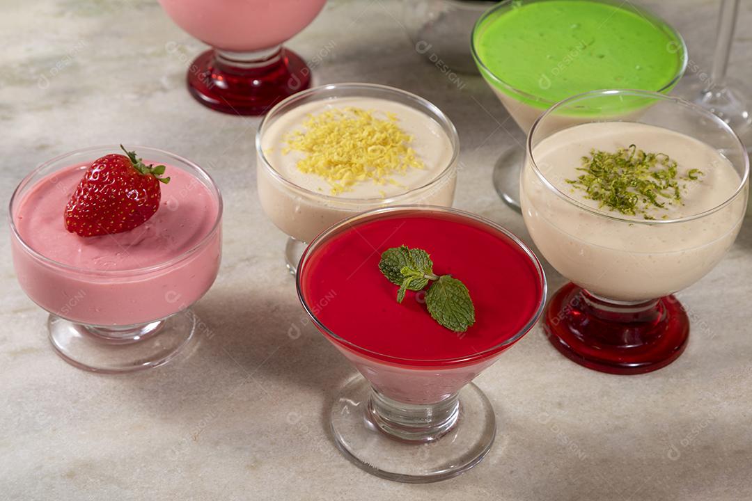 Deliciosos mousses de limão e morango em frascos de vidro em cima Imagem JPG