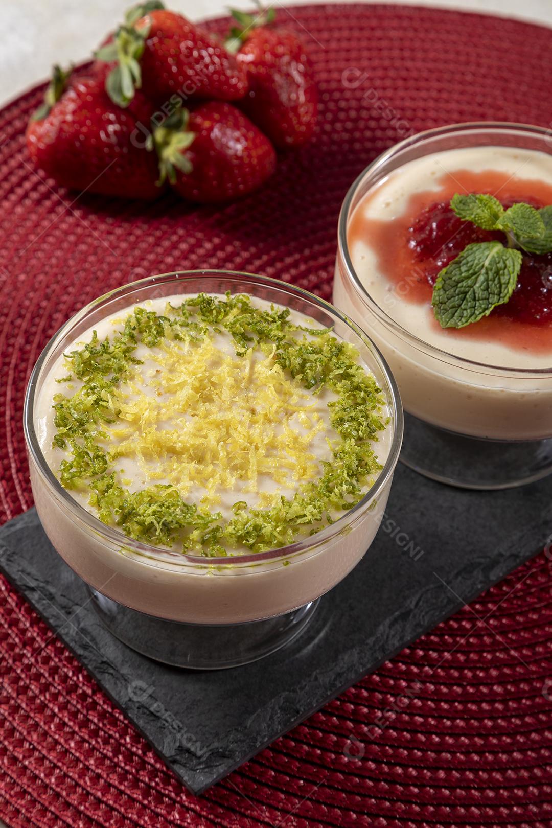 Deliciosos mousses de limão e morango em frascos de vidro em cima Imagem JPG