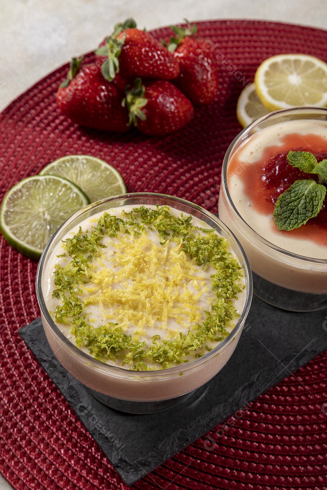 Deliciosos mousses de limão e morango em frascos de vidro em cima Imagem JPG