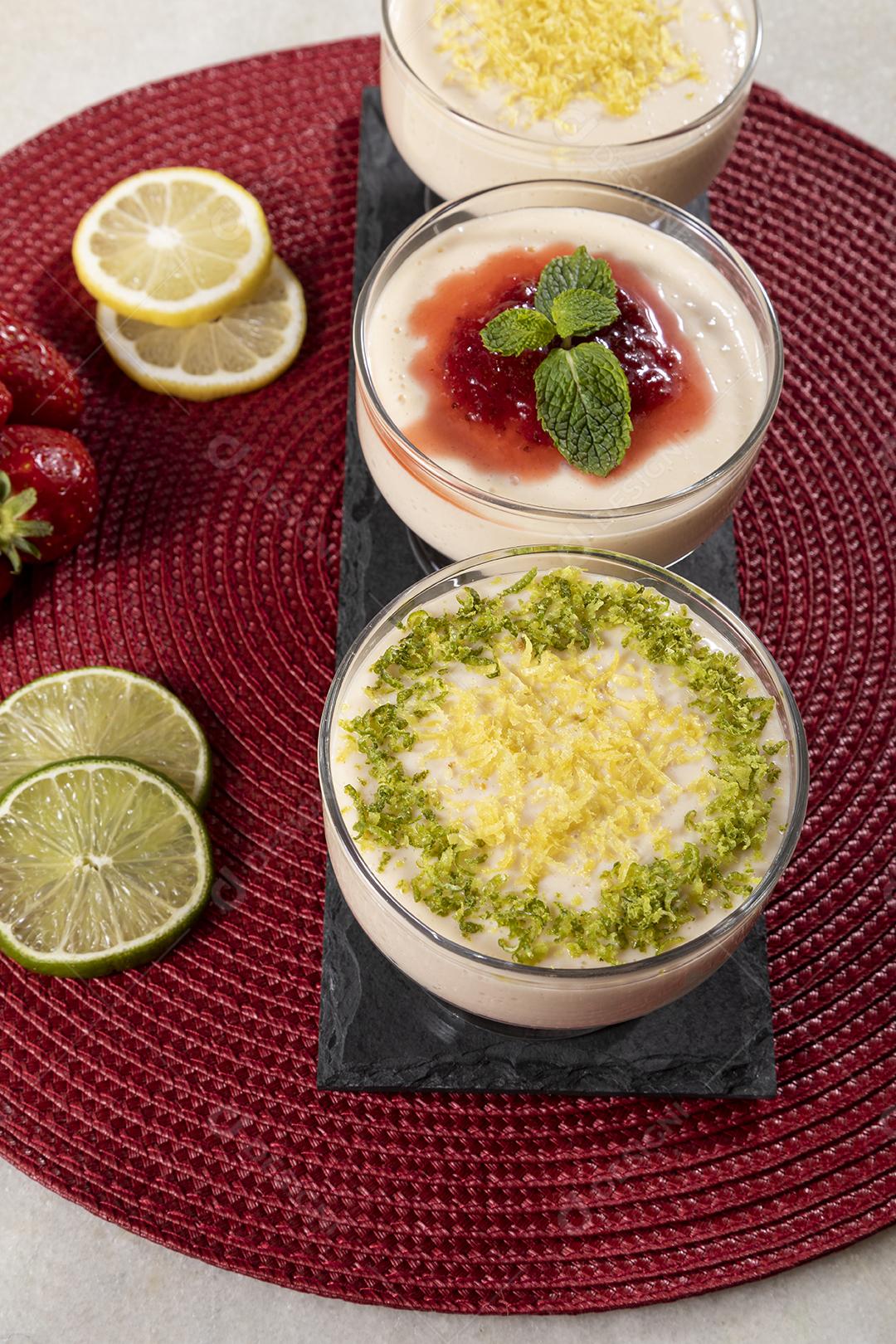 Deliciosos mousses de limão e morango em frascos de vidro em cima Imagem JPG