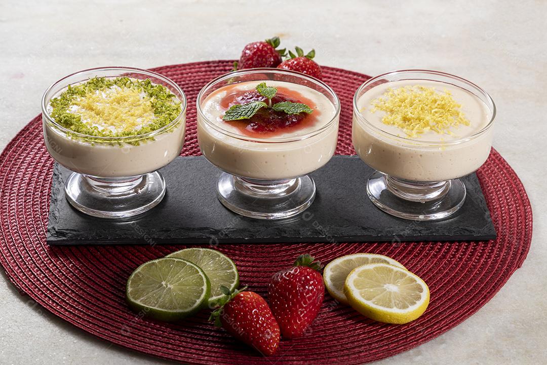 Deliciosos mousses de limão e morango em frascos de vidro em cima Imagem JPG