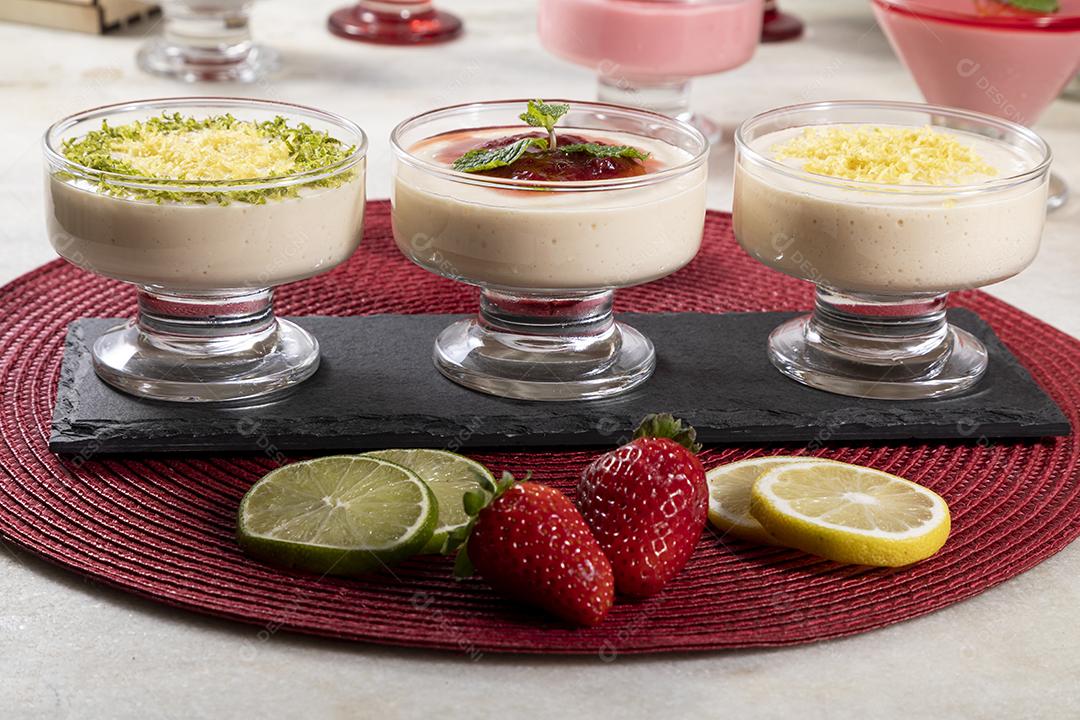 Deliciosos mousses de limão e morango em frascos de vidro em cima Imagem JPG