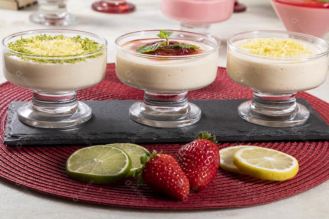Deliciosos mousses de limão e morango em frascos de vidro em cima Imagem JPG