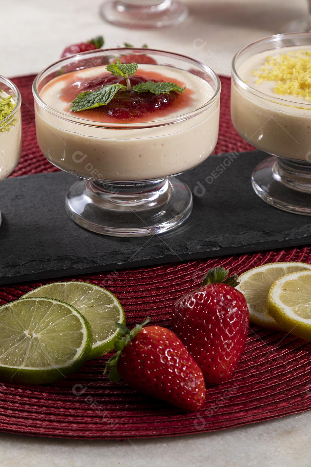 Deliciosos mousses de limão e morango em frascos de vidro em cima Imagem JPG