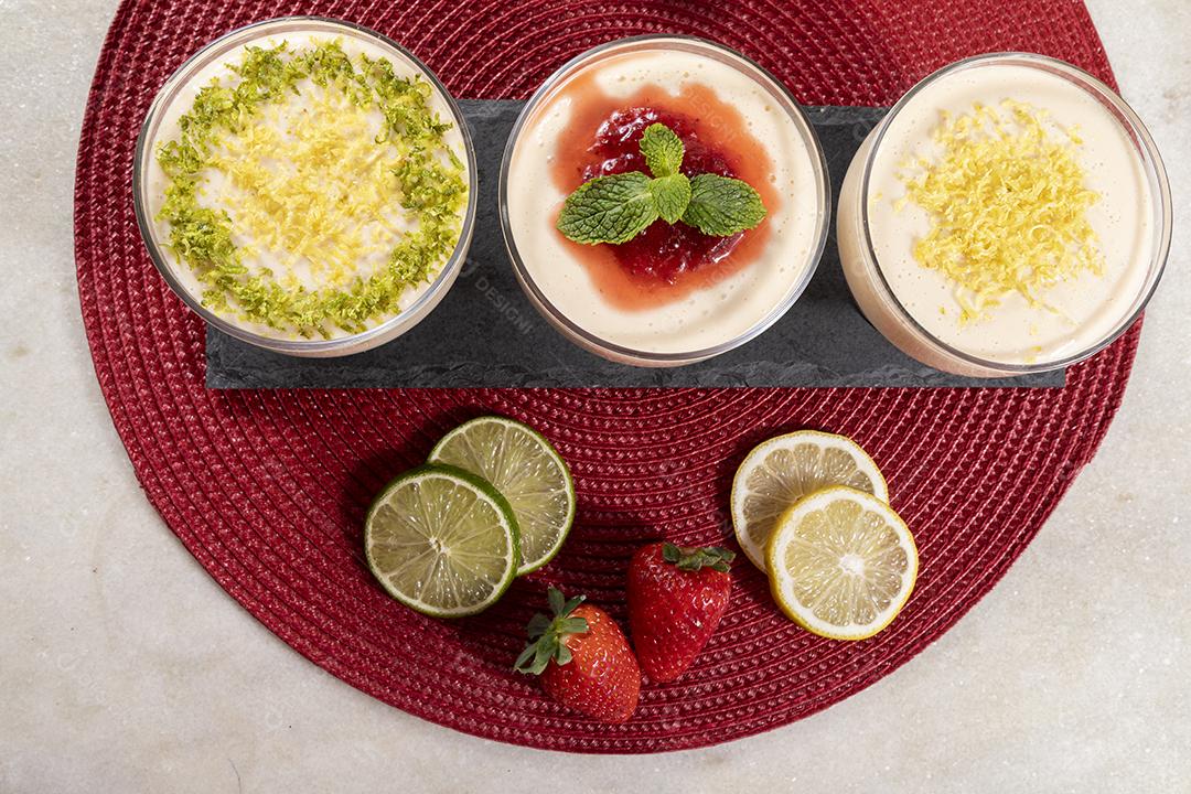 Deliciosos mousses de limão e morango em frascos de vidro em cima Imagem JPG