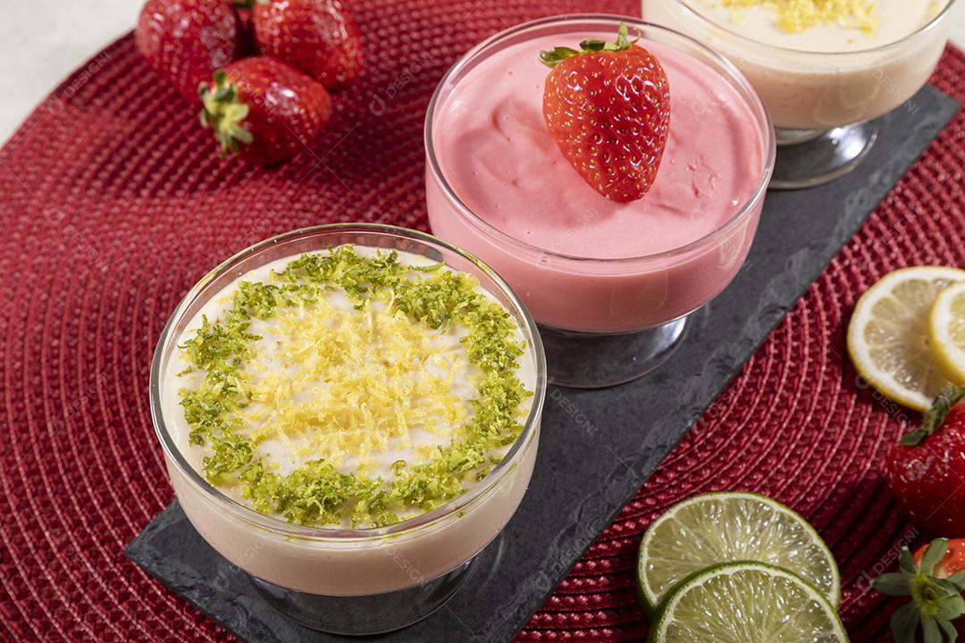 Deliciosos mousses de limão e morango em frascos de vidro em cima Imagem JPG