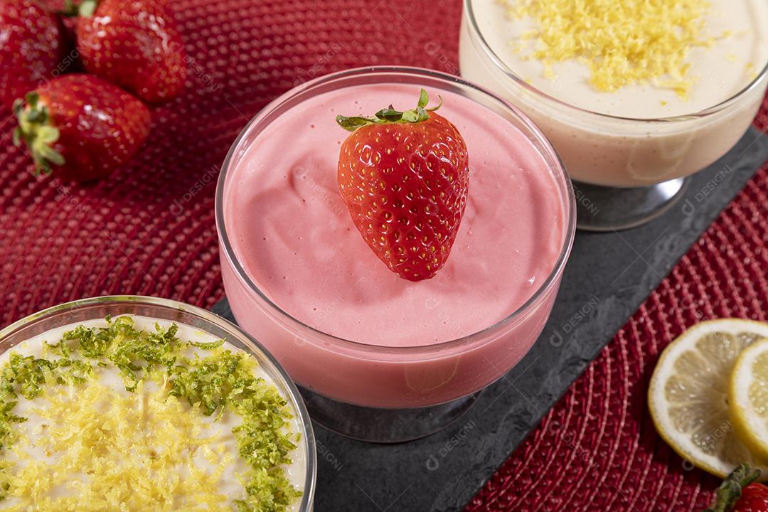 Deliciosos mousses de limão e morango em frascos de vidro em cima Imagem JPG