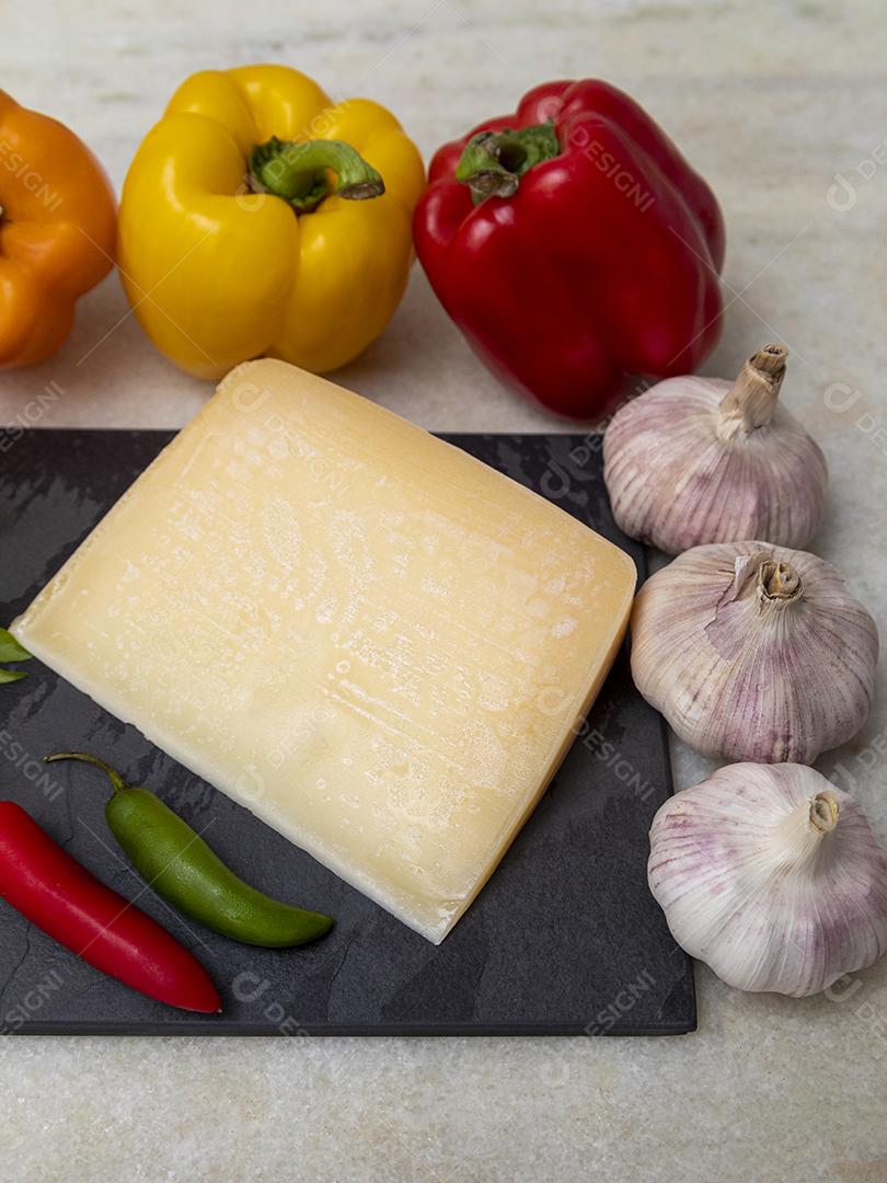 Queijo parmesão no tabuleiro de pedra preta com especiarias