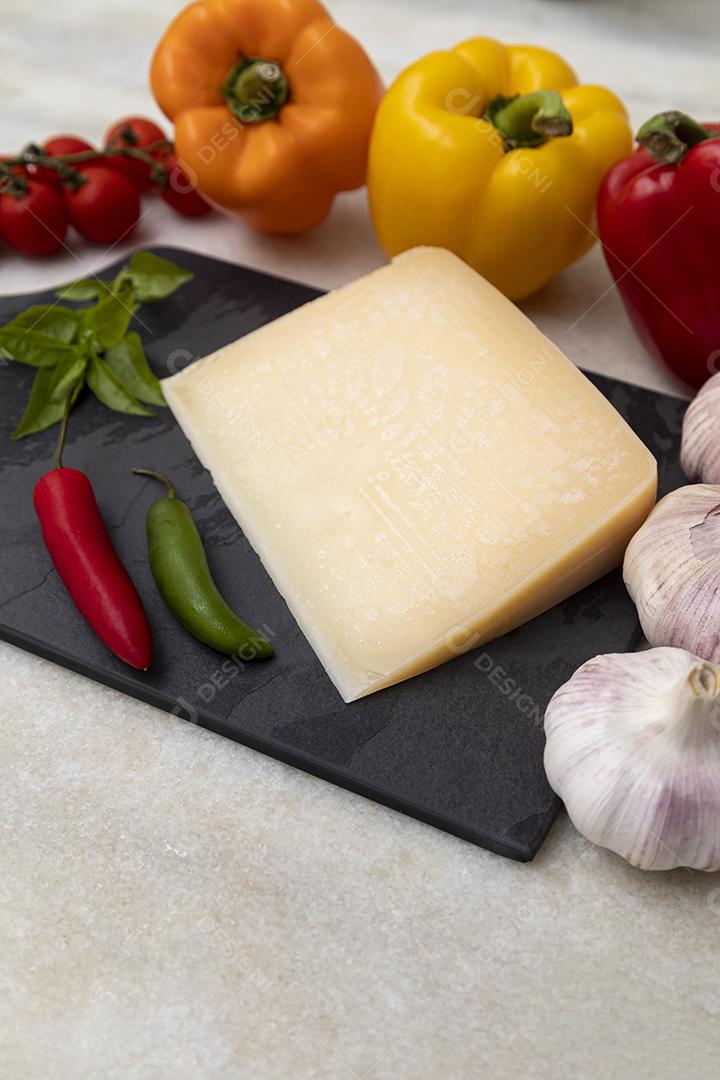 Queijo parmesão no tabuleiro de pedra preta com especiarias