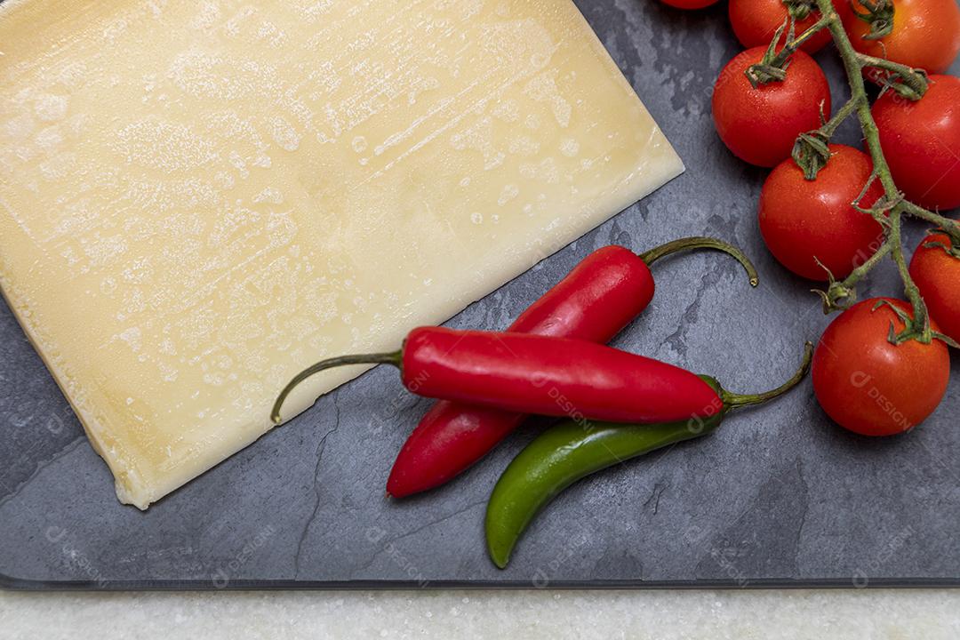 Parmesan cheese on black stone tray with spices