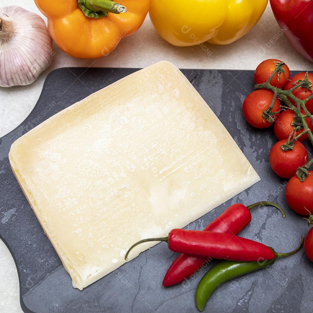 Queijo parmesão no tabuleiro de pedra preta com especiarias