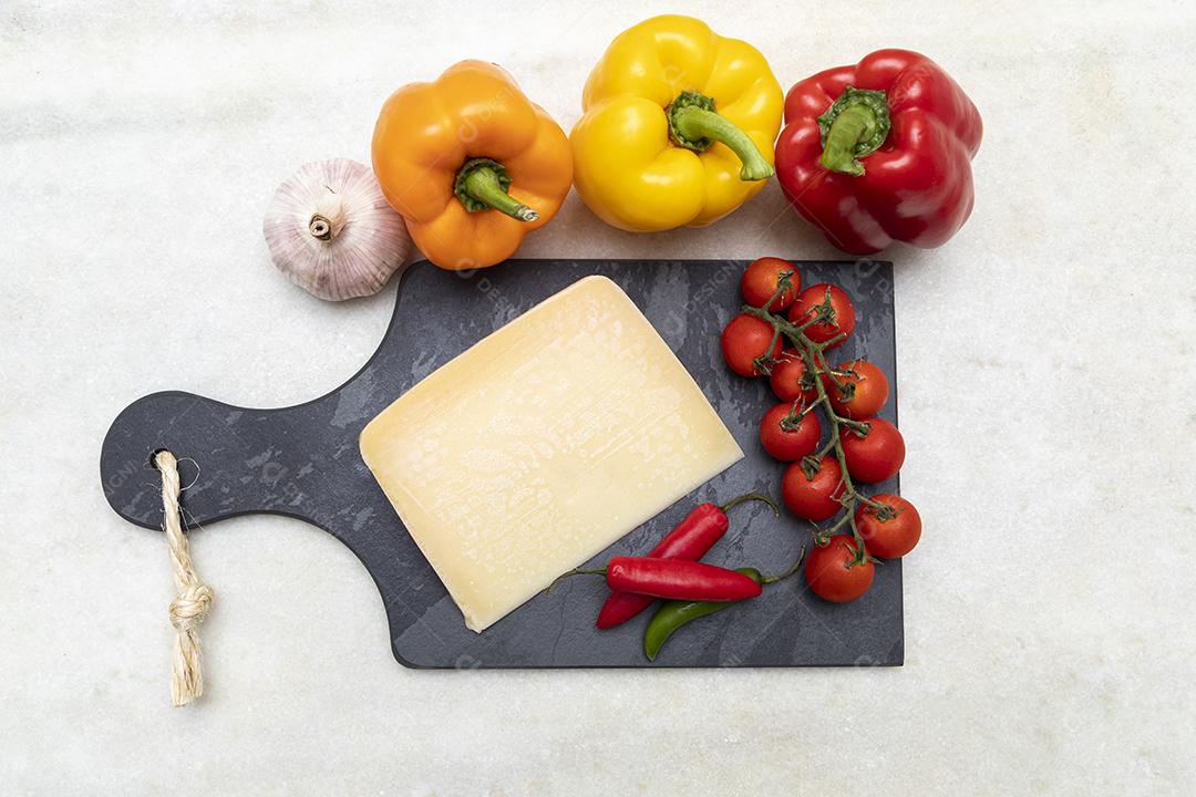 Queijo parmesão no tabuleiro de pedra preta com especiarias