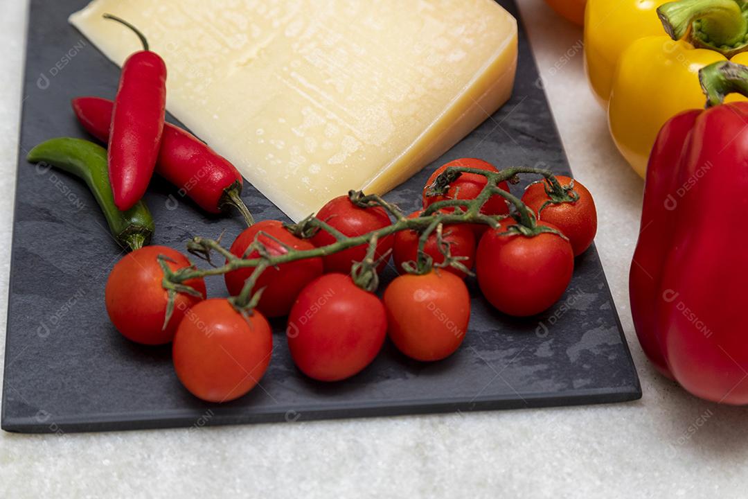 Queijo parmesão no tabuleiro de pedra preta com especiarias