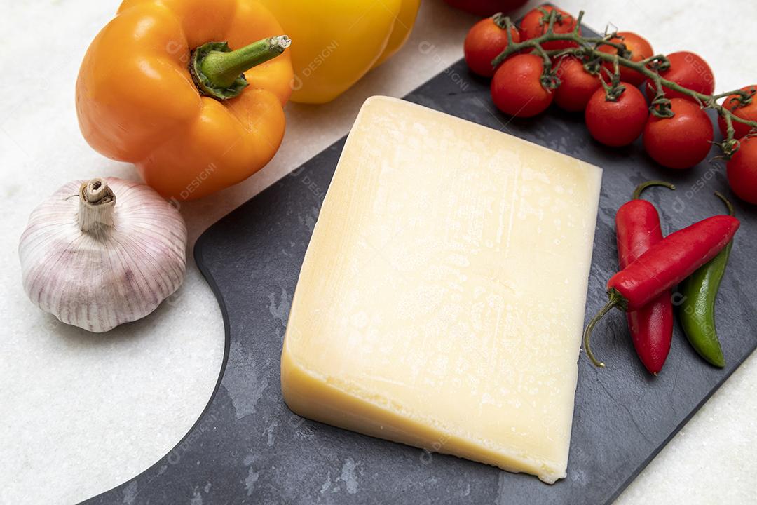 Queijo parmesão no tabuleiro de pedra preta com especiarias