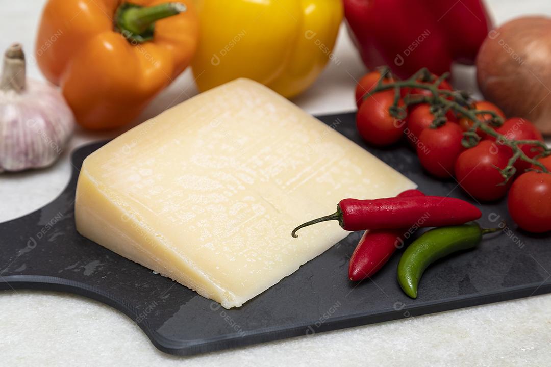 Queijo parmesão no tabuleiro de pedra preta com especiarias